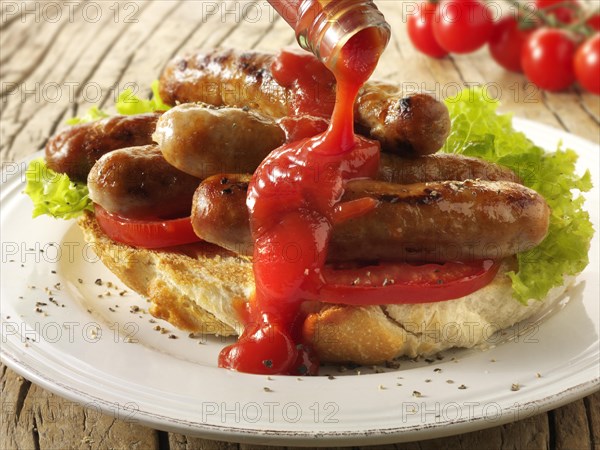 Traditional chipolata pork sausages with tomato ketchup sandwich