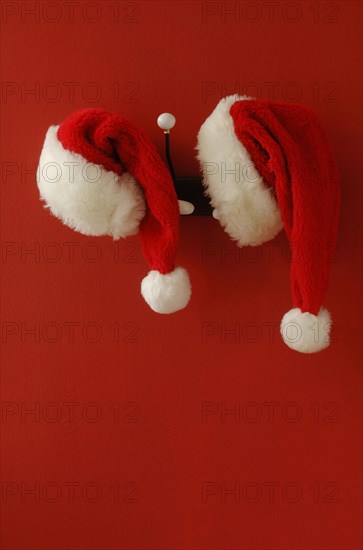 Two Santa hats on hanging on nostalgic coat hooks