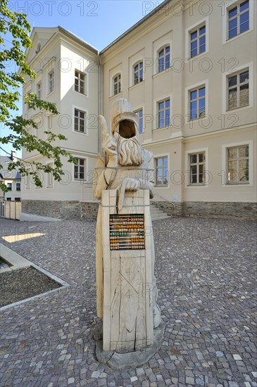 Wooden sculpture of Adam Ries in front of the Adam Ries educational centre