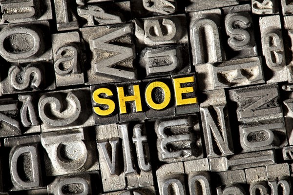 Old lead letters forming the word 'SHOE'