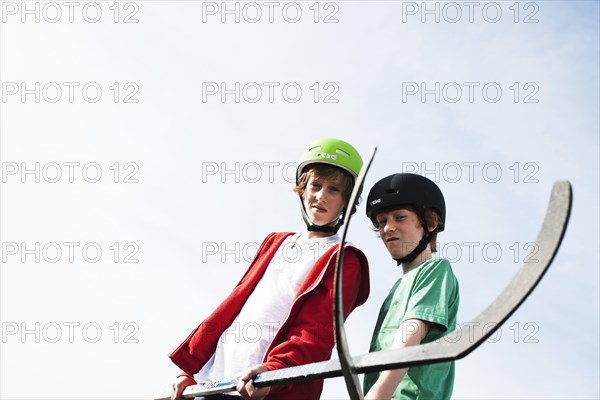 Two cool boys playing roller hockey with hockey sticks