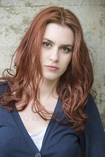 Portrait of a confident young woman with red hair