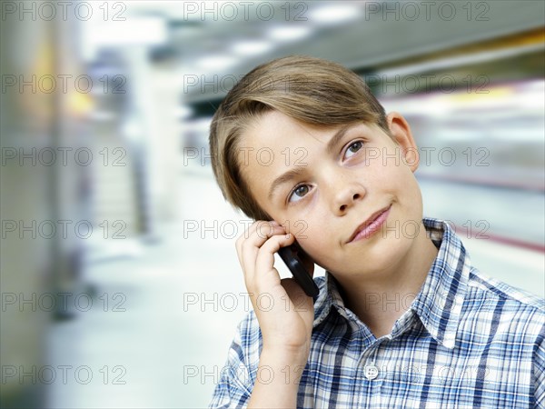 Teenager using a mobile phone in an underground railway station