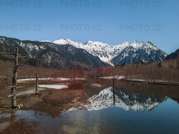 Snow-covered Japanese Alps reflected in Lake Taisho Pond