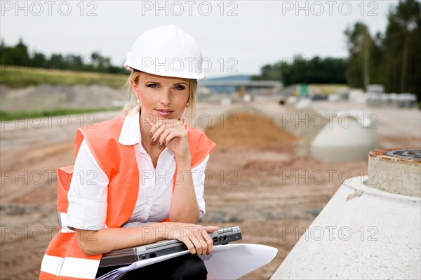 A young female constructor at building of a new motorway