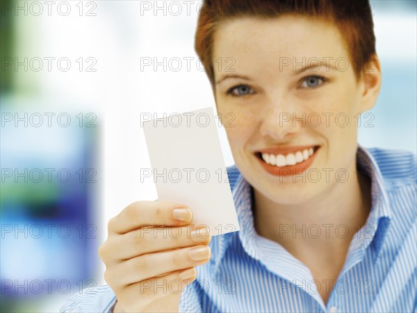Businesswoman holding a blank business card
