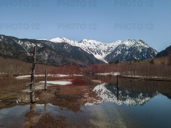 Snow-covered Japanese Alps reflected in Lake Taisho Pond
