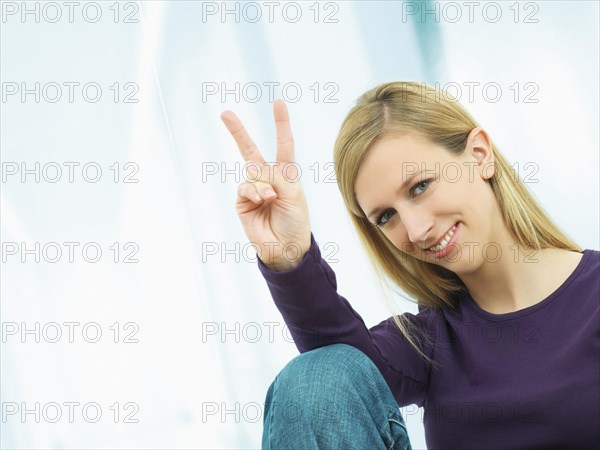 Young woman making a V sign with her hand