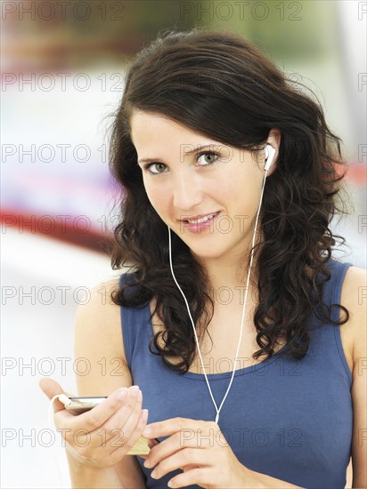 Young woman listening to music at a subway station