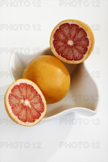 Ruby grapefruit cut open in porcelain bowl