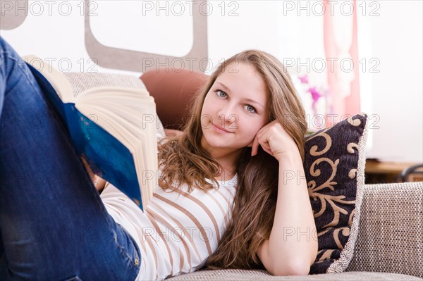 Girl reading a book on the sofa