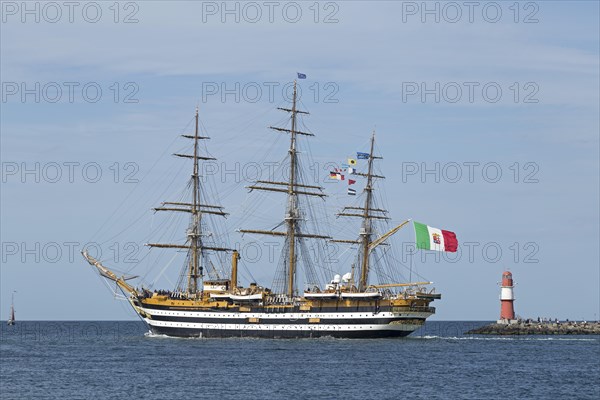 Italian sailing training ship Amerigo Vespucci passes pier lights at the entrance to the Unterwarnow