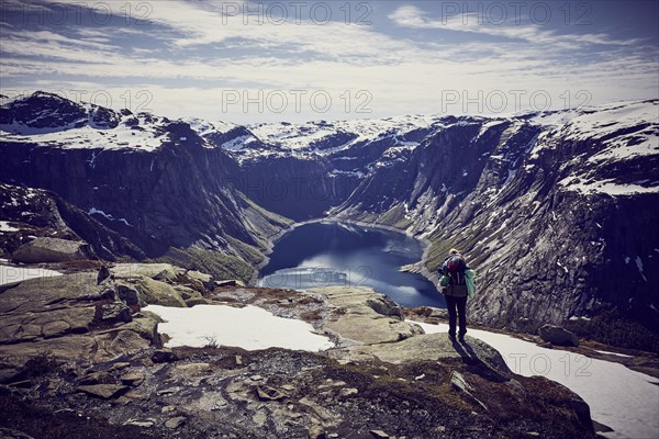 Young woman climbing to Trolltunga