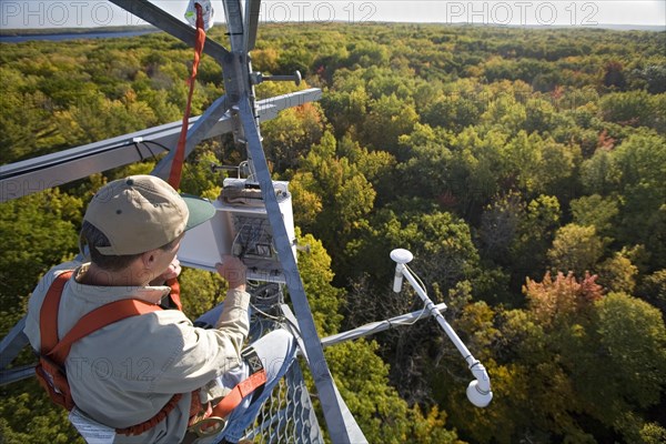 Dr. Chris Vogel checks instruments on a 150-foot tower above the forest canopy