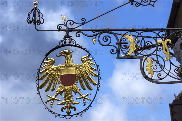 Hanging shop sign with golden eagle