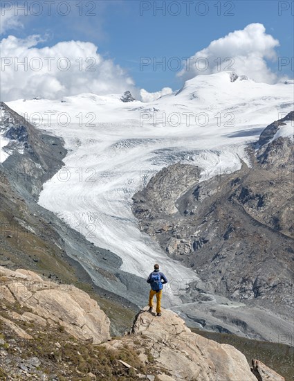 Hiker looks from the mountain Unterrothorn onto the glacier tongue of the Findel Glacier