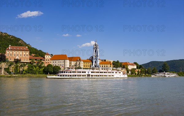 Excursion boat on the Danube in front of the baroque church of the monastery Duernstein