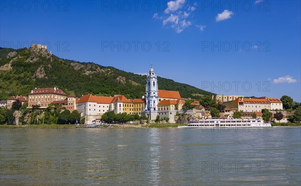 Excursion boat on the Danube in front of the baroque church of Duernstein Abbey