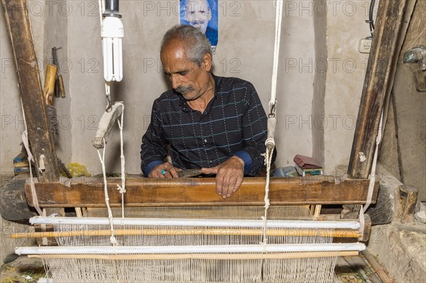 Iranian man working on a loom