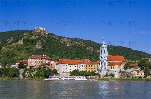 Excursion boat on the Danube in front of the baroque church of Duernstein Abbey