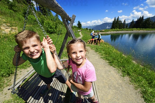 Family playing during a hike at the storage lake at the middle station