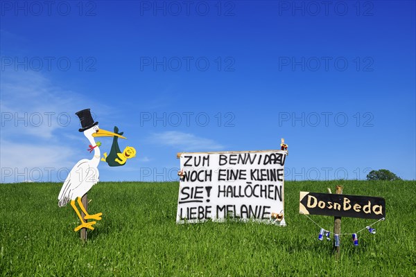 Rattling stork and banner as a welcome for a newborn child