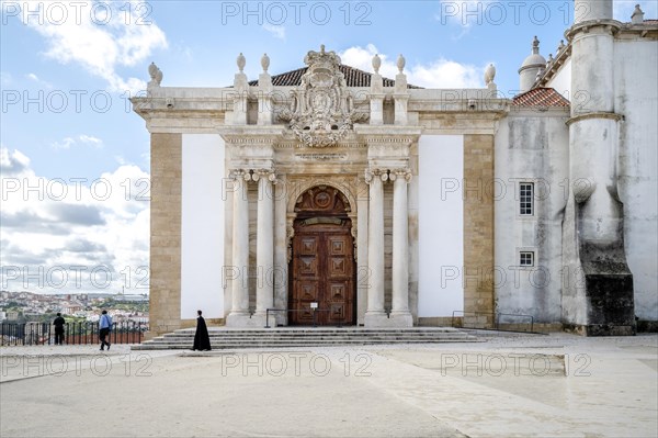 A student in traditional cloth walking through University of Coimbra