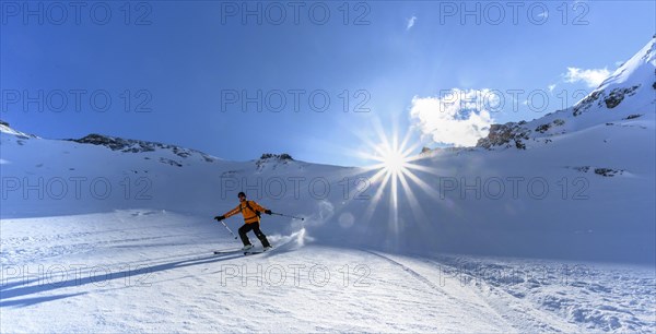 Skier with touring skis skiing in the snow