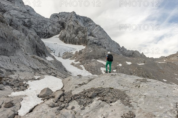 Hiker looks at alpine landscape