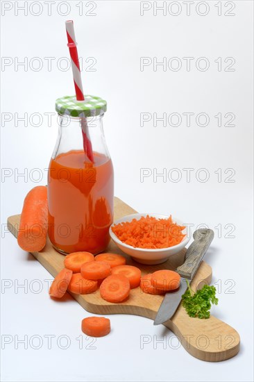 Carrot juice in bottle and carrot slices