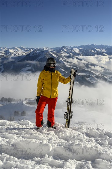 Skier standing at the ski slope holding ski
