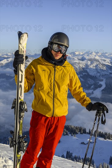 Skier standing at the ski slope holding ski