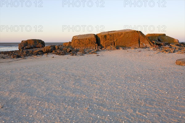 Bunker remains of an anti-aircraft gun position from World War II on the Minsener Oog power station in the evening light