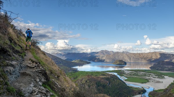 Hiker on the hiking trail to Rocky Peak, views of Wanaka Lake and mountains