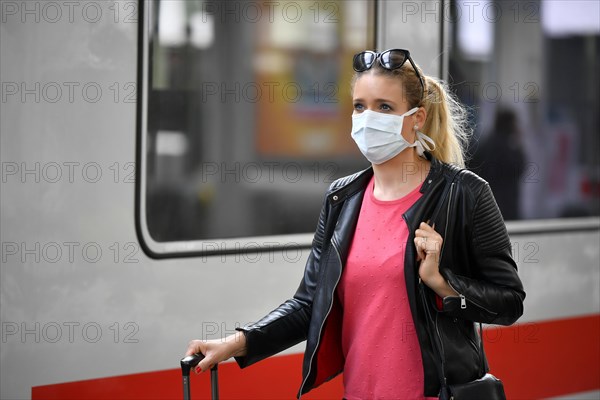 Woman with face mask, waiting for train
