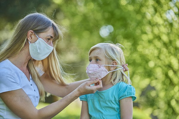 Mother ties daughter face mask
