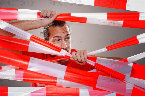 Young man with barrier tape in red and white