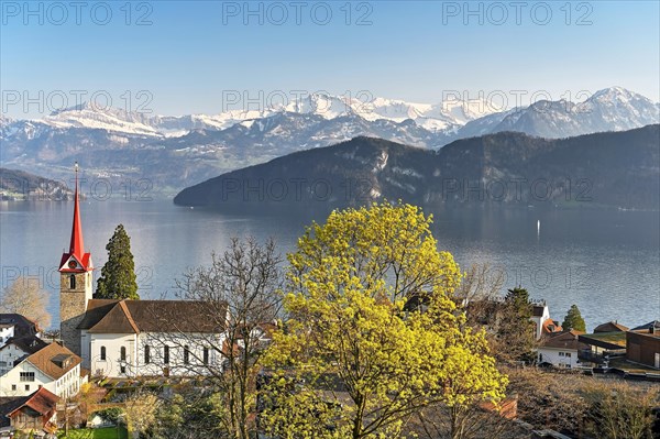 Holiday destination on Lake Lucerne with the parish church of St. Mary behind the snow-covered Alps
