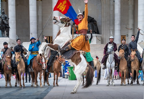 Young horse rider man a rising horse in front of the Parliament house during NAADAM festival