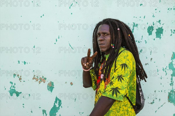 Rasta at a decayed wall of crumbling plaster