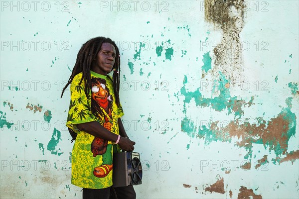 Rasta at a decayed wall of crumbling plaster