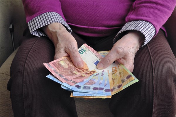 Hand of a senior citizen with euro notes