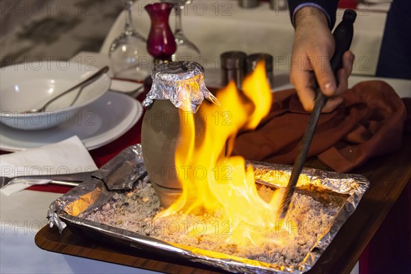 Testi Kebab is served with fire in a restaurant