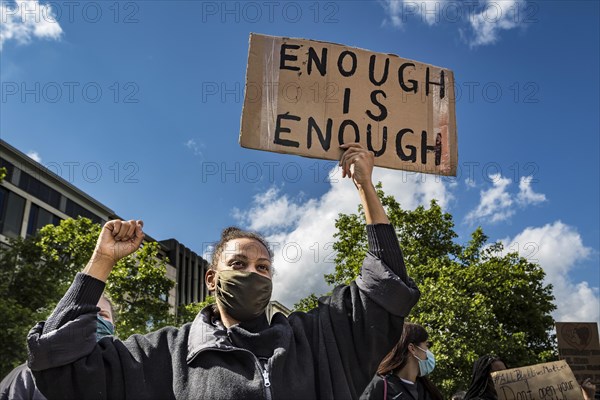 Dark-skinned demonstrator with poster with the inscription Enough is Enough