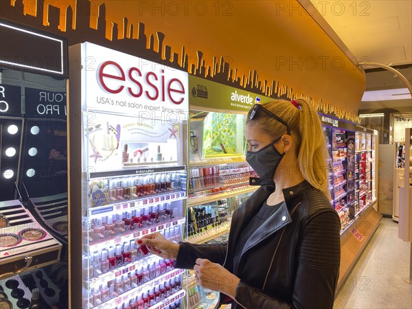 Woman wearing a face mask while shopping in the cosmetics department