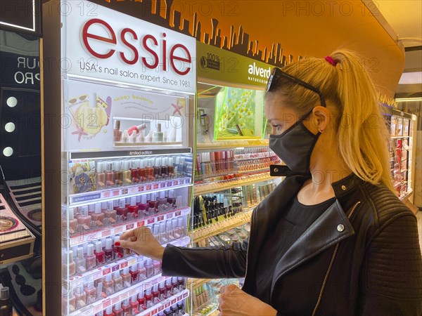 Woman wearing a face mask while shopping in the cosmetics department