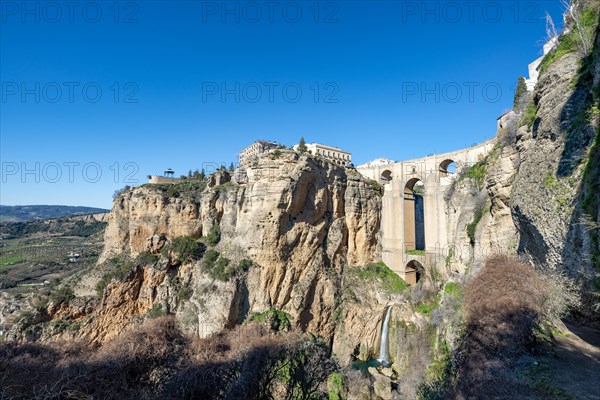 Bridge Puente Nuevo with waterfall at steep cliffs