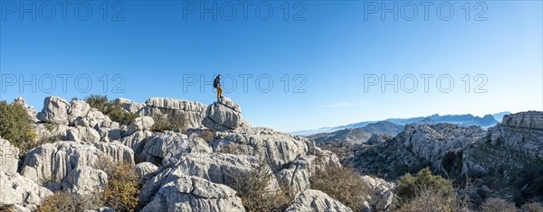 Young man standing on rocks and looking into the distance
