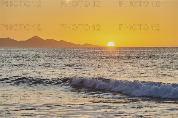 Beach Playa de la Pared with rocky coast at sunset