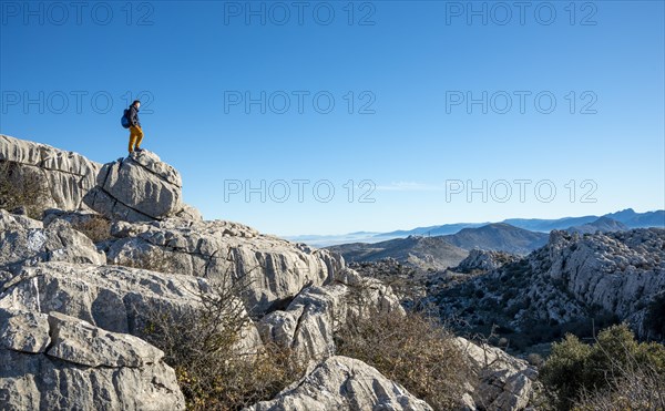 Young man standing on rocks and looking into the distance